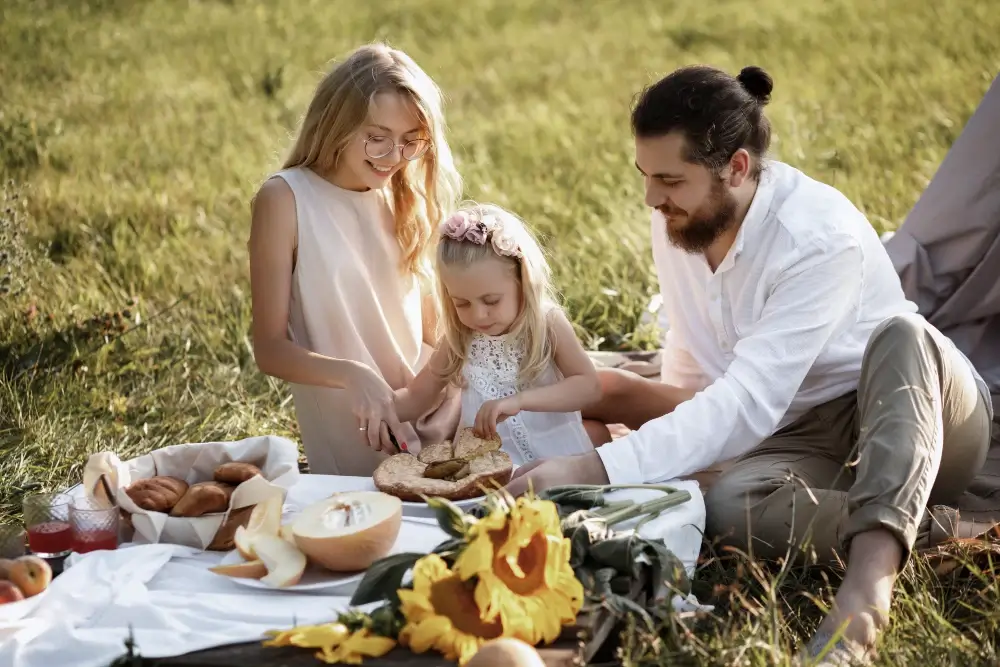 családi lifestyle fotózás a szabadban egy családdal piknikeznek a réten